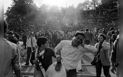 Supporters flee 29 May 1985 the scene of riots in Heysel football stadium in Brussels after thirty-nine Juventus football fans died during rioting at the European Cup Final in Brussels. Shortly before kick off the atmosphere turned violent and Liverpool supporters stampeded through a thin line of police towards the rival fans. As the Juventus fans retreated a wall collapsed under the pressure and fans were crushed and trampled to death in the panic. AFP PHOTO DOMINIQUE FAGET / AFP PHOTO / DOMINIQUE FAGET        (Photo credit should read DOMINIQUE FAGET/AFP via Getty Images)