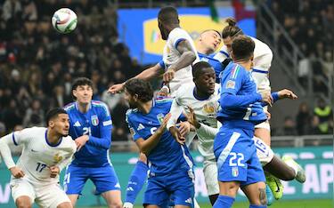 France's forward #14 Adrien Rabiot (up R) scores the opening goal during the Nations League group A2 football match between Italy and France at San Siro stadium in Milan, on November 17, 2024. (Photo by Alberto PIZZOLI / AFP)