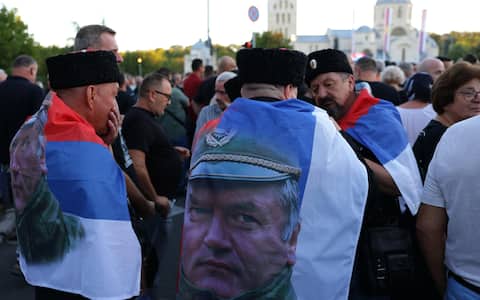 epa13218923 Men draped in flags depicting Ratko Mladic during his funeral in Belgrade, Serbia, 07 September 2026. Former Bosnian Serb general Ratko Mladic, who was convicted of war crimes by the International Criminal Tribunal for the Former Yugoslavia (ICTY) in 2017, died on 27 August 2026 at the age of 84.  EPA/ANDREJ CUKIC
