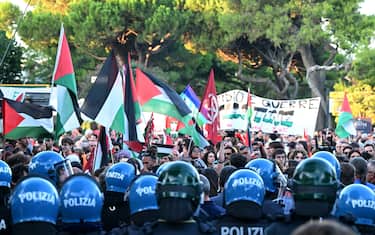 Anti-riot policemen face protesters at the end of a march in support of Gaza and Palestinian people at Venice Lido during the 82nd Venice International Film Festival, on August 30, 2025. (Photo by Stefano RELLANDINI / AFP)