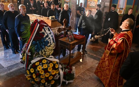 Mourners stand past the coffin of late Bosnian Serb military leader Ratko Mladic while taking part in a public memorial on the day of his funeral ceremony at St Lukas church in Belgrade, on September 7, 2026. Mladic, 84, died last week after suffering several strokes while serving a life sentence in The Hague for war crimes committed during the 1990s war in Bosnia. (Photo by OLIVER BUNIC / AFP)
