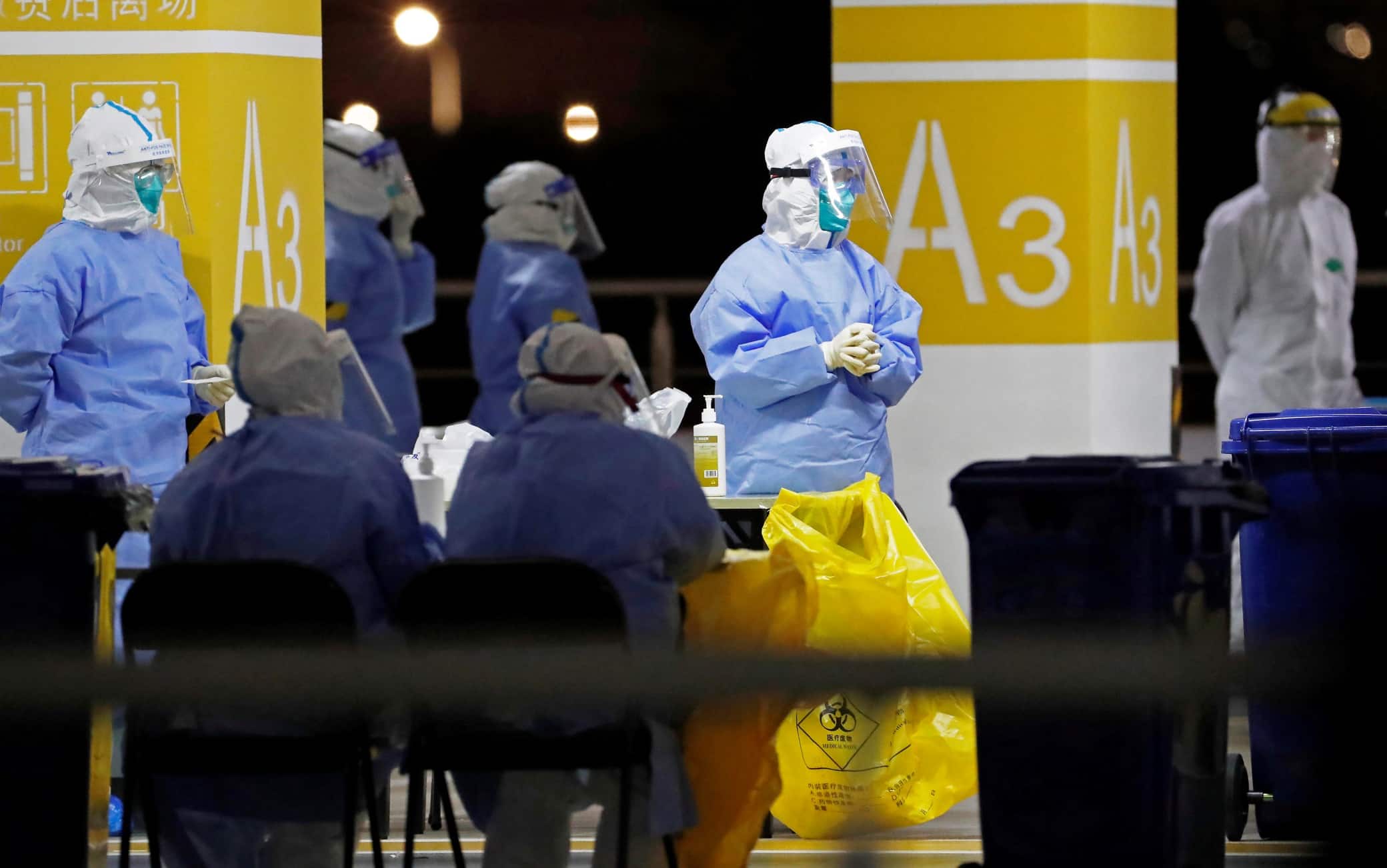 This photo taken on November 22, 2020 shows health workers in protective suits waiting to conduct COVID-19 coronavirus tests on staff at Pudong Airport in Shanghai. (Photo by STR / CNS / AFP) / China OUT (Photo by STR/CNS/AFP via Getty Images)