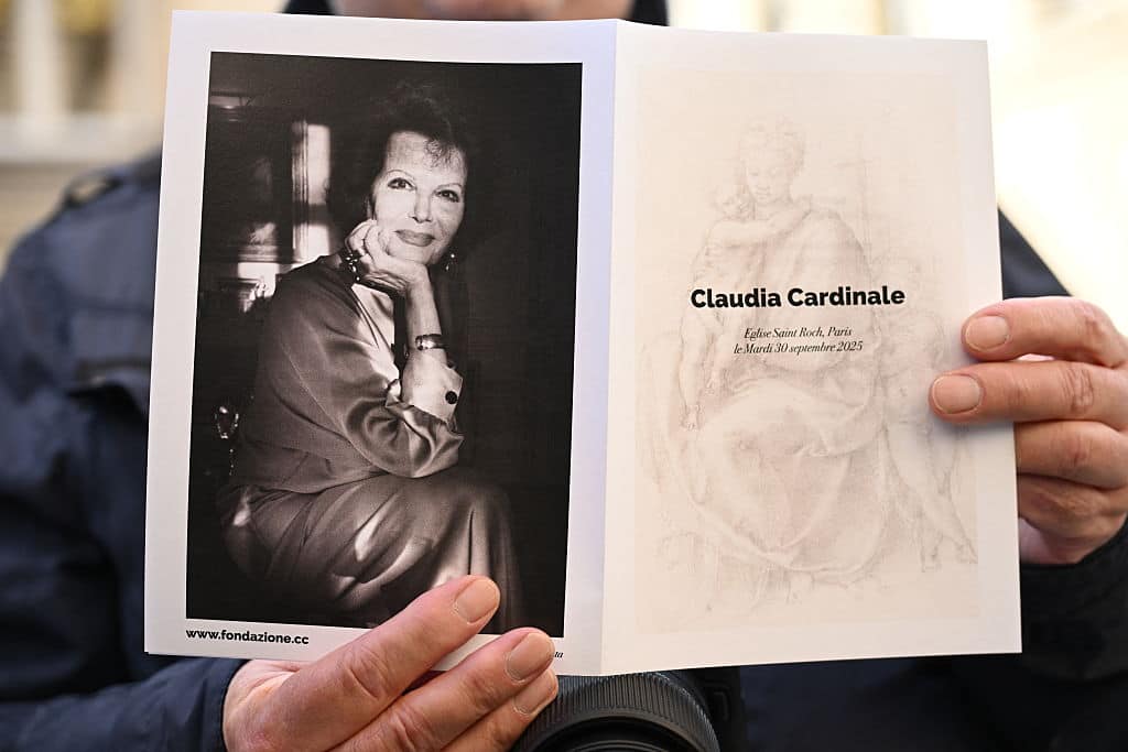 A mourner holds a funeral service booklet ahead of the funeral ceremony of Italian actress Claudia Cardinale at the Saint-Roch Church in Paris, on September 30, 2025. Italian actress Claudia Cardinale, who appeared in films by some of Italy's greatest filmmakers as well as Hollywood classics, died on September 23, 2025 aged 87, in Nemours, France. (Photo by Bertrand GUAY / AFP) (Photo by BERTRAND GUAY/AFP via Getty Images)          