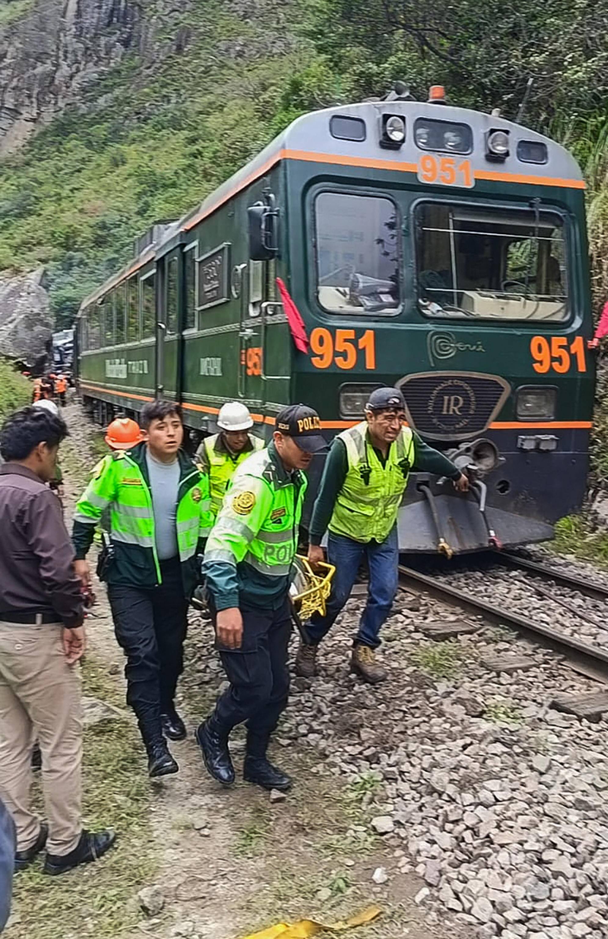 Police officers carry an injured passenger from one of the two trains affected after a head-on collision connecting Machu Picchu with Ollantaytambo in Pampacahua, Cusco Department, Peru, on December 30, 2025. On December 30, 2025, a head-on collision between two trains on the line that services Peru's Machu Picchu killed one person and injured at least 40 others, authorities said, updating an earlier toll. (Photo by Carolina Paucar / AFP)