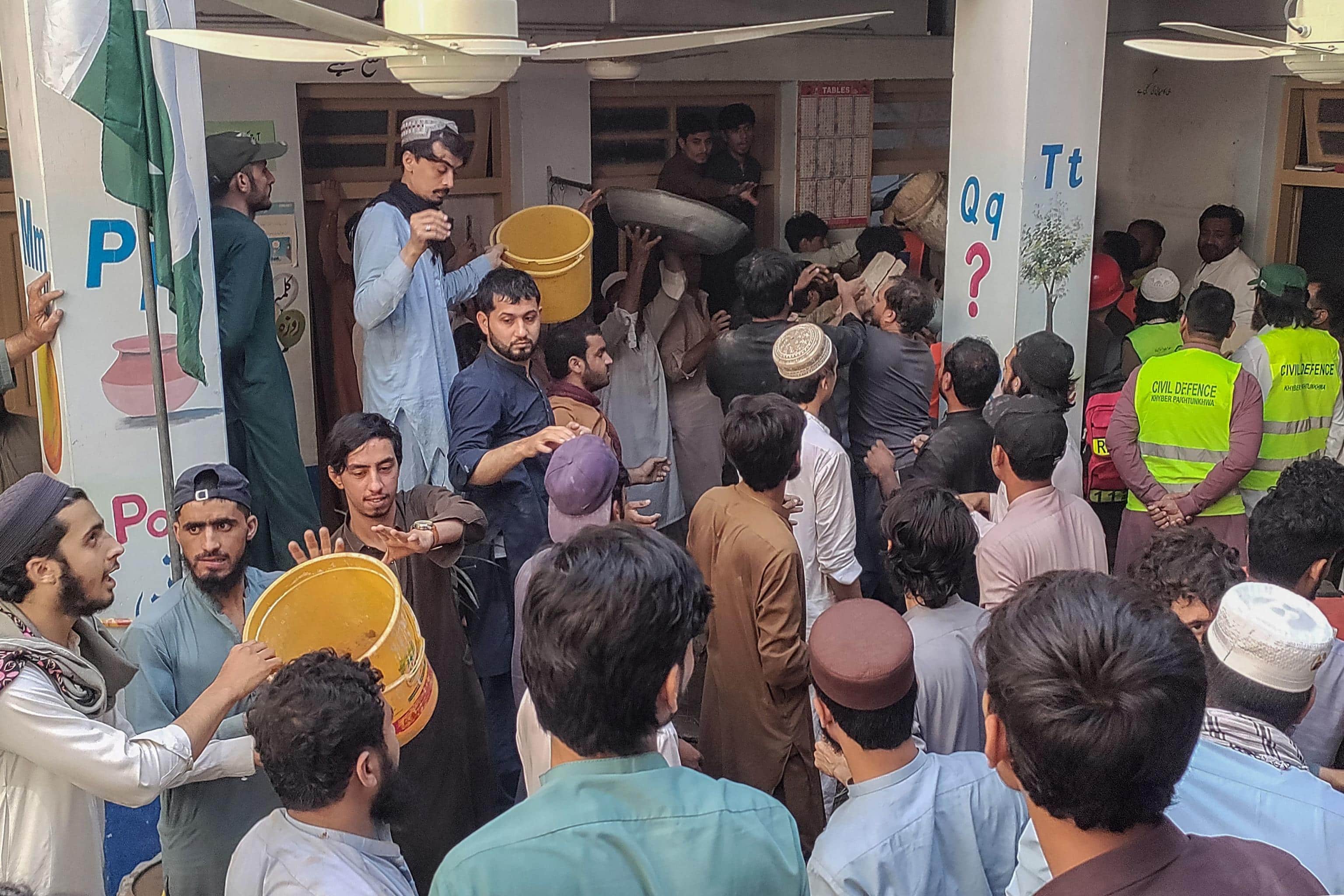 Rescuers and residents conduct a search operation after a roof collapsed at a school in Peshawar on October 15, 2026. Sixteen pupils and a teacher were killed on October 15 after a roof collapsed at a school in the northwest Pakistani city of Peshawar, emergency services said. (Photo by Abdul MAJEED / AFP)