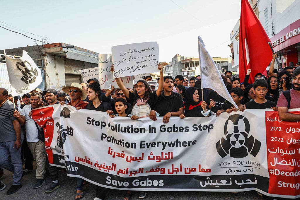 Teenagers hold a large banner reading ''stop pollution in Gabes, stop pollution everywhere, save Gabes'' while shouting slogans during a mass protest that brings together thousands of residents in Gabes, Tunisia, on October 15, 2025, to protest and demand the dismantling of the units of the Tunisian Chemical Group (GCT). The mobilization comes after a surge in cases of respiratory problems, poisonings, and illnesses affecting students at a middle school located near the phosphate processing plant, sparking anger among a population exposed to chemical risks for more than fifty years. In 2017, Tunisian authorities promise the gradual dismantling of the polluting units of the Gabes chemical complex following strong protests against pollution. However, this decision is never fully implemented, and the population continues to suffer from massive pollution. (Photo by Chedly Ben Ibrahim/NurPhoto via Getty Images)