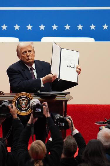 WASHINGTON, DC - JANUARY 20: U.S. President Donald Trump holds up an executive orders after signing it during an indoor inauguration parade at Capital One Arena on January 20, 2025 in Washington, DC. Donald Trump takes office for his second term as the 47th president of the United States. (Photo by Christopher Furlong/Getty Images)