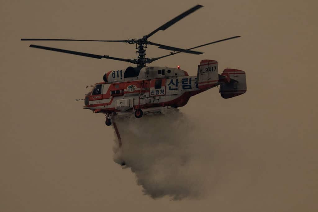A helicopter takes part in an operation to extinguish a wildfire in Uiseong on March 24, 2025. South Korean authorities said on March 24 they would deploy dozens of helicopters and thousands of firefighters and soldiers as they struggle to control multiple wildfires in the southeast, which have been burning for days. (Photo by YASUYOSHI CHIBA / AFP) (Photo by YASUYOSHI CHIBA/AFP via Getty Images)          