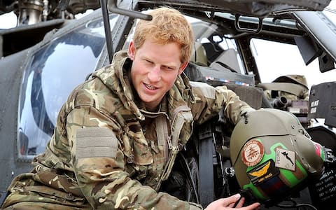 CAMP BASTION, AFGHANISTAN - DECEMBER 12:  In this image released on January 21, 2013, Prince Harry, shows a television crew his flight helmet as he makes early morning checks as he sits on an Apache helicopter at the British controlled flight-line at Camp Bastion on December 12, 2012 in Afghanistan. Prince Harry has served as an Apache Helicopter Pilot/Gunner with 662 Sqd Army Air Corps, from September 2012 for four months until January 2013.  (Photo by John Stillwell - WPA Pool/Getty Images)