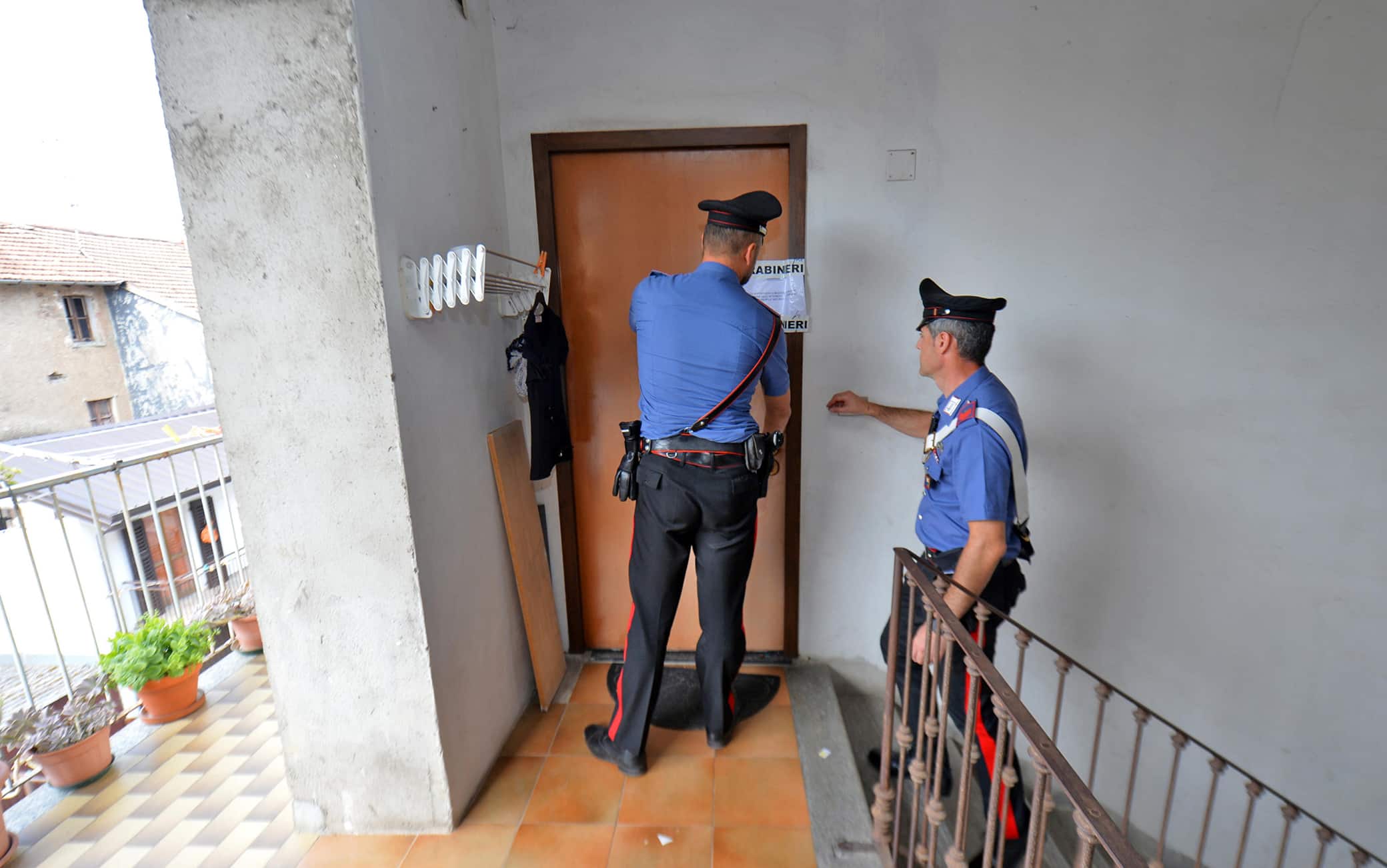 I carabinieri davanti l'ingresso dell'abitazione di Carmela Fabozzi la donna di 73 anni trovata morta nel suo appartamento di Malnate (Varese), 23 luglio 2022. ANSA/Agenzia Blitz Varese