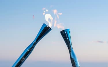 GENOA, ITALY - JANUARY 09: The Olympic fire of Milano Cortina 2026 passes from torch to torch during the Olympic Torch Relay on January 09, 2026 in Genoa, Italy. (Photo by Emanuela Zampa/Getty Images)