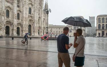Milano, Piazza Duomo. Bomba d'acqua con pioggia a scroscio da classico temporale estivo sorprende molti turisti in piazza fra selfie e k-way