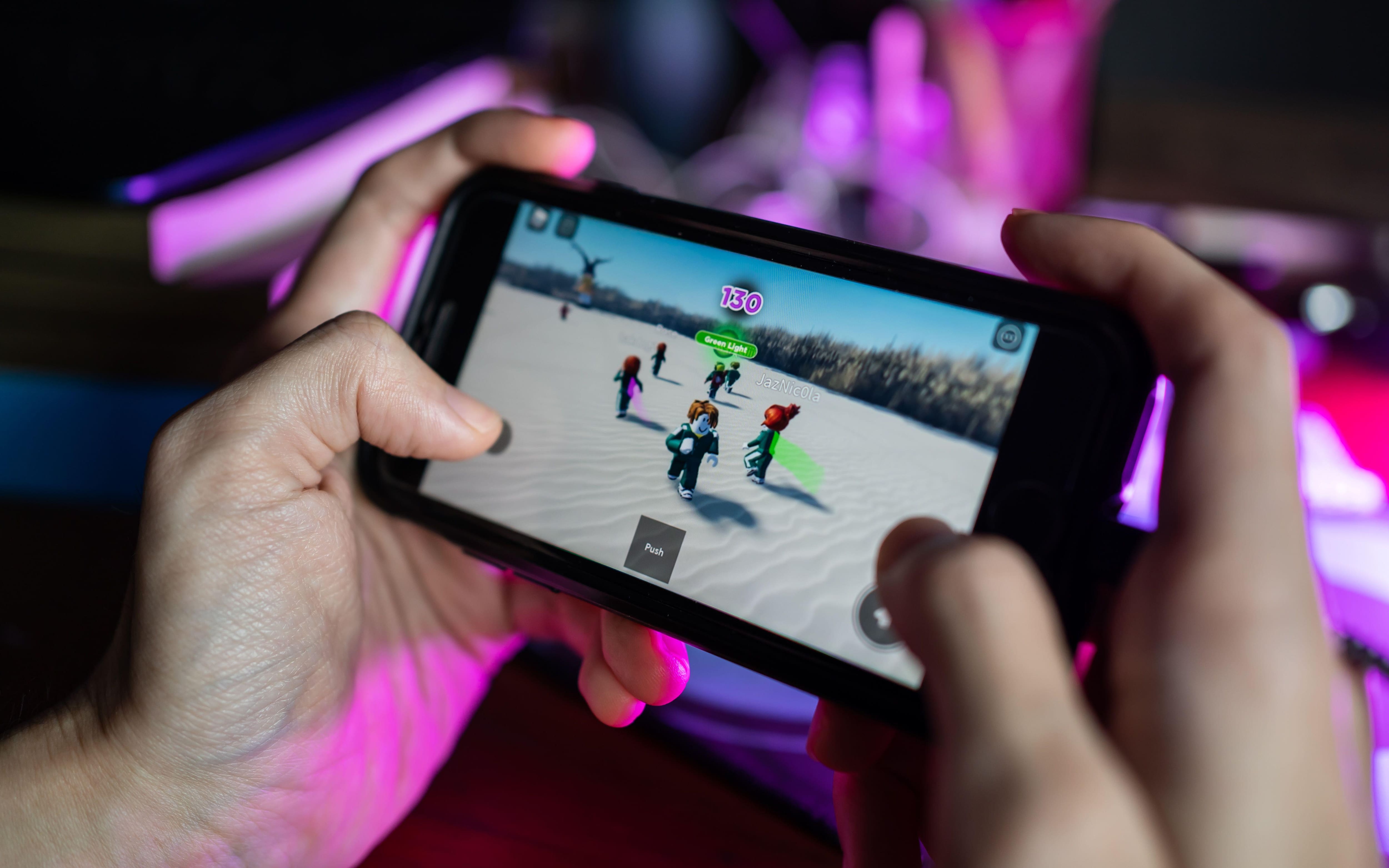 2H9AYH7 Bangkok, Thailand - November 20, 2021 : Gamer playing Roblox game on iPhone 7.