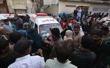epa12756285 Rescue workers and people gather at the site of a residential compound following a suspected gas leakage blast in Karachi, Pakistan, 19 February 2026. At least 16 people, including women and children, were killed and 18 injured after a suspected gas explosion caused part of a residential building to collapse in Karachi's Soldier Bazaar area, officials said.  EPA/REHAN KHAN