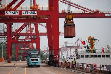 epa12128133 A crane loads containers from a cargo ship onto trucks at Yangluo Port during an organized press trip in Wuhan, Hubei province, China, 23 May 2025. Yangluo Port, located on the north bank of the Yangtze River in eastern Wuhan, is a key deep-water port with depths ranging from 7 to 15 meters. It is the largest container hub along the middle and upper reaches of the Yangtze River, serving as a vital 'gateway to the sea' for central and western China.  EPA/ALEX PLAVEVSKI