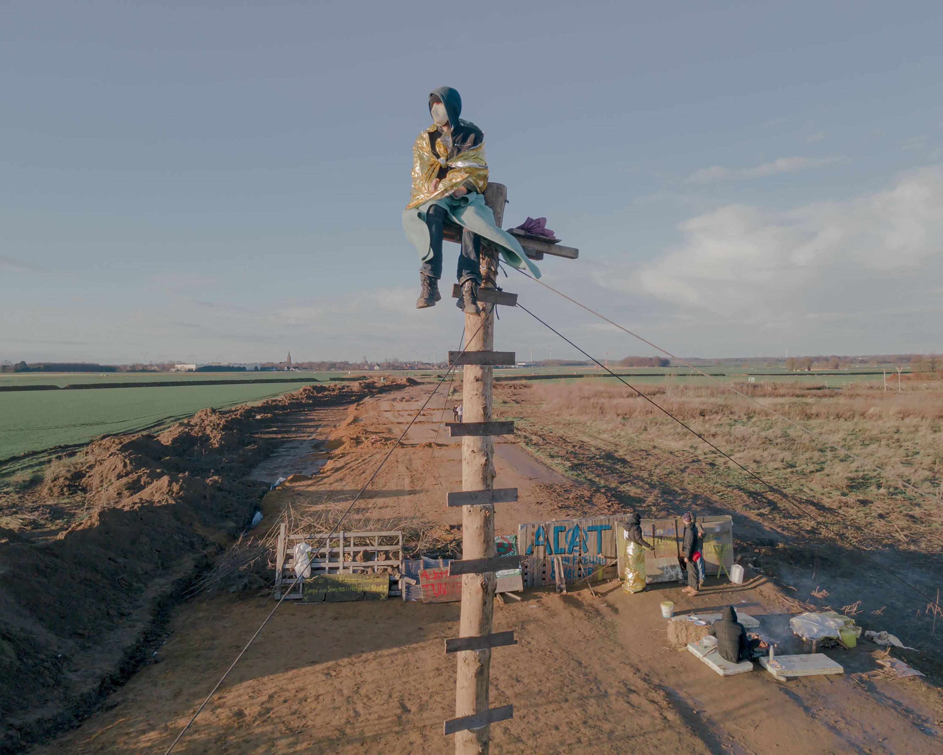 An activist sits on a monopod at the entrance of Lützerath, Germany on January 08, 2023. The police need special forces, lifting platforms and cranes to clear such constructions.