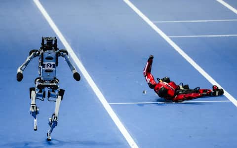 epa13184806 A humanoid robot runs past another one that fell down during a 100 m event at the 2026 World Humanoid Robot Games in the National Speed Skating Oval in Beijing, China, 22 August 2026. The 2026 World Humanoid Robot Games are being held in Beijing until 26 August.  EPA/WU HAO