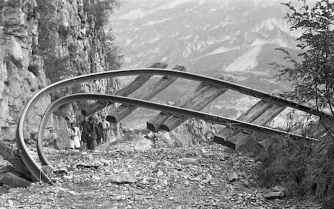 A twisted railroad track rises from the rubble, Longarone, near the Vajont Dam in the Piave Valley, Italy, early October, 1963. On October 9, a landslide in the dam basin caused a wave more than 800 feet high to overtop the dam and flood the valley below--five villages were completely destroyed, more than 2000 people were killed, and thousands more were left homeless and displaced. (Photo by Archivio Cameraphoto Epoche/Getty Images)