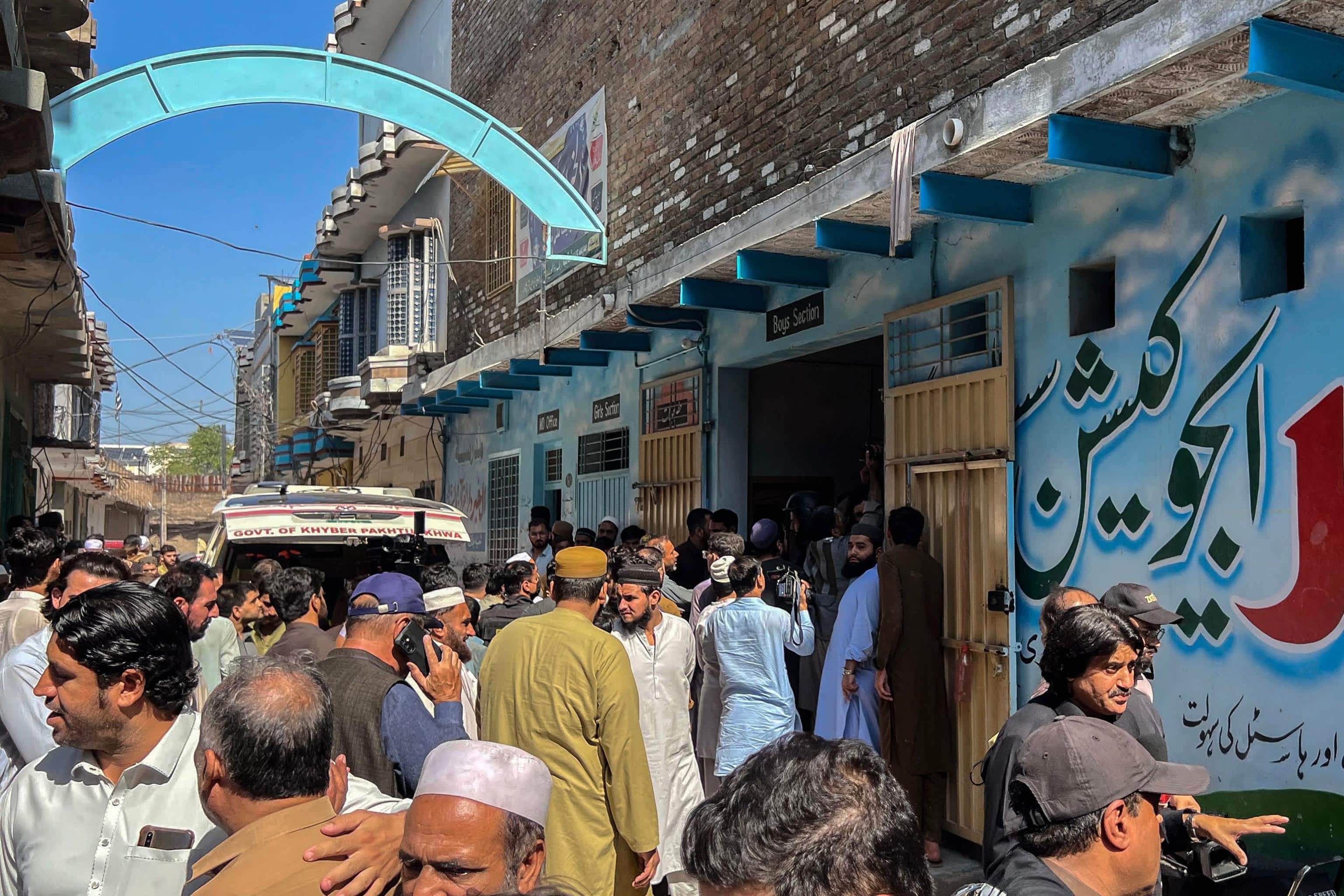 Residents gather during a search operation after a roof collapsed at a school in Peshawar on October 15, 2026. Sixteen pupils and a teacher were killed on October 15 after a roof collapsed at a school in the northwest Pakistani city of Peshawar, emergency services said. (Photo by Abdul MAJEED / AFP)