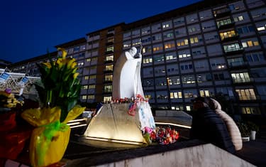 People pray in front of the statue of John Paul II at the entrance to the Gemelli Hospital, where Pope Francis is hospitalized, in Rome, Italy, 6 March 2025. ANSA/FABIO FRUSTACI