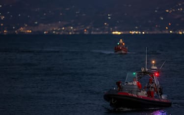 Rescue workers and divers from the Italian fire brigade as a rescue operation continues for the missing people who were on board a sailboat that sank, in Porticello, Sicily Island, Italy, 20 August 2024. At least one person died, six remain missing and 15 passengers were rescued, after a 56-meter-long luxury sailboat, the Bayesian, with 22 people on board, sank on 19 August off Porticello, near Palermo, after a tornado hit the area. The six missing people have not yet been identified as dive teams are trying to find access into the yacht's cabins, sitting at 50 m below the surface of the water.ANSA/IGOR PETYX