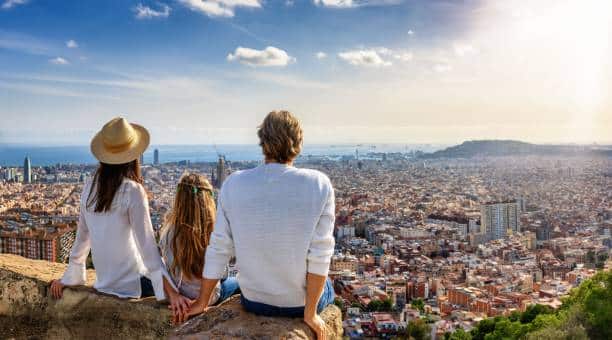 A family enjoys the panoramic view of the skyline of Barcelona, Spain, during their city trip vacation