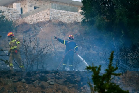 epa13140358 Firefighters work to extinguish a fire in low vegetation near Krya Vrysi, Rethymno, Crete, Greece, 29 July 2026. More than 150 firefighters, supported by four helicopters and four firefighting aircraft, were deployed to tackle the blaze. Two firefighters died while battling the fire, according to the Greek Fire Service.  EPA/NIKOS CHALKIADAKIS