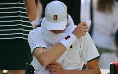 Italy's Jannik Sinner uses a towel as he plays against Serbia's Miomir Kecmanovic during their men's singles first round tennis match on the first day of the 2026 Wimbledon Championships at The All England Lawn Tennis and Croquet Club in Wimbledon, southwest London, on June 29, 2026. (Photo by Glyn KIRK / AFP) / RESTRICTED TO EDITORIAL USE