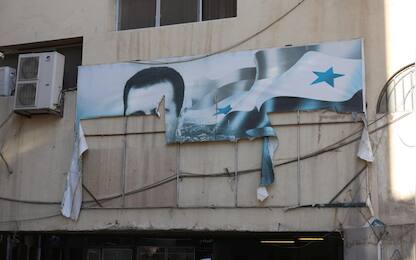 epa11765465 A torn banner depicting the picture of Bashar al-Assad on a building after rebels took over Damascus, Syria, 08 December 2024. Syrian rebels entered Damascus on 08 December 2024 and announced in a televised statement the 'Liberation of the city of Damascus and the overthrow of Bashar al-Assad,' as well as the release of all the prisoners. The rebels also urged the Syrian armed forces to leave Syrian public institutions, which will stay under the control of the outgoing Syrian prime minister until the official handover ceremony  EPA/MOHAMMED AL RIFAI