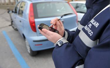 20090310-PONTEDERA (PI)-CLJ -CASSAZIONE:MULTE IN STRISCE BLU, POTERE RIDOTTI AI 'VIGILINI'. Un vigilino donna fotografata questo pomeriggio a Pontedera in un parcheggio a strisce blu. La Cassazione diminuisce il 'potere di multa' ai dipendenti delle societa' che gestiscono i posteggi a pagamento su concessione del comune: i 'vigilini' non possono fare le multe per ogni tipo di infrazione che si verifica  nell'area di posteggio ma solo per le infrazioni dentro le strisce blu. Per questo la Suprema Corte - con la sentenza 5621 - ha respinto un ricorso del comune di Parma contro la decisione del giudice di pace che aveva stracciato la multa inflitta da vigilini per sosta vietata a un guidatore che aveva parcheggiato  l'auto nella zona in concessione per il posteggio a pagamento mettendola in uno spazio non contrassegnato dalle strisce blu. ANSA/FRANCO SILVI /KLD