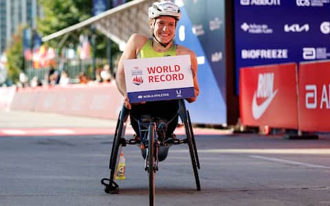 Swiss wheelchair racer Catherine Debrunner celebrates at the finish line after winning the women's professional wheelchair division during the 2026 Chicago Marathon in Chicago, Illinois on October 11, 2026. She finished with an unofficial world record time of 1:33:16. (Photo by KAMIL KRZACZYNSKI / AFP)