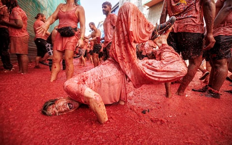 epa13192502 Participants have fun after the battle with overripe tomatoes during the traditional 'Tomatina' fiesta in Bunol, Valencia, Spain, on August 26, 2026. Thousands of people attend the annual event, where overripe tomatoes are thrown during the traditional tomato fight.  EPA/BIEL ALINO