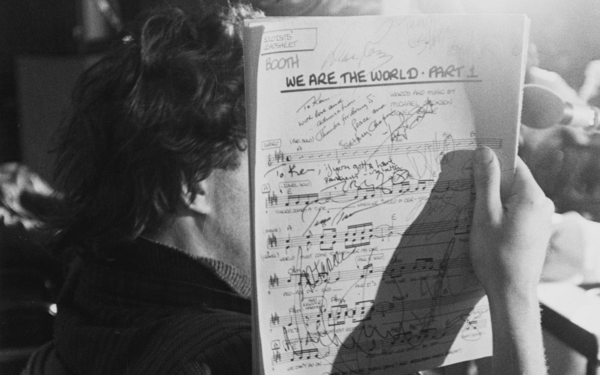 Irish singer-songwriter Bob Geldof obscured by the autographed sheet music for the charity single 'We Are the World' at A&M Recording Studios in Los Angeles, California, January 1985. The song, written by Michael Jackson and Lionel Richie, was recorded by 'USA for Africa' to raise awareness and funds for a worldwide hunger relief program.  (Photo by Vinnie Zuffante/Getty Images)