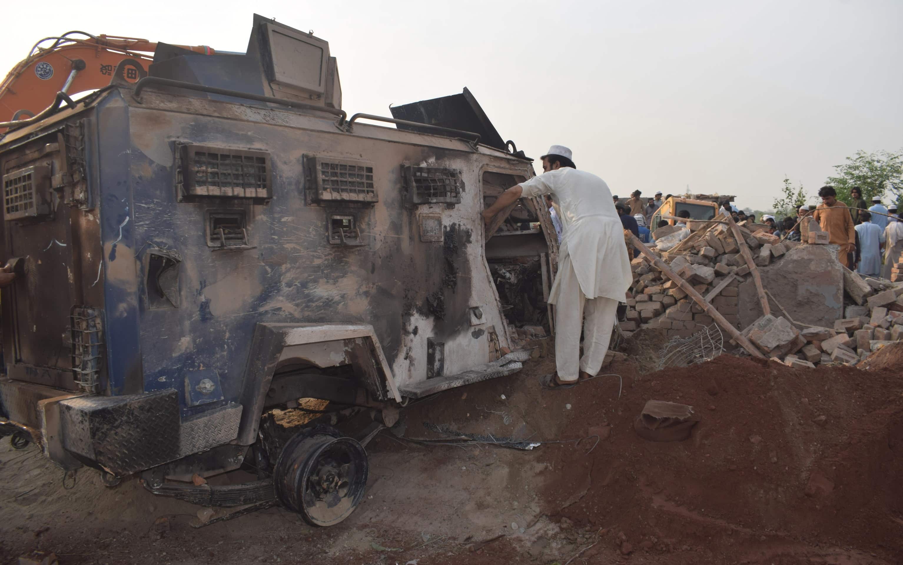 epa12944920 People survey the scene of an overnight car bomb attack at a police post in Bannu, KPK province, Pakistan, 10 May 2026. According to police officials, at least 12 police personnel were killed and several others injured after an explosives-laden vehicle struck the checkpoint, followed by an exchange of fire with militants in the northwestern Bannu district bordering Afghanistan.  EPA/WASEEM KHAN