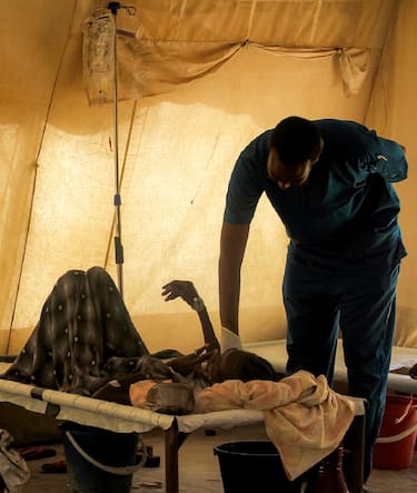 A doctor visits a cholera patient at an isolation unit outside the Bashayer Hospital, south of Khartoum on May 31, 2025. In Khartoum, where a cholera outbreak has killed dozens this week, doctors struggled to treat patients with dwindling supplies as the disease rapidly spread. In other overwhelmed hospitals across the war-ravaged capital, medics have been forced to lay patients on floors in hallways and courtyards. (Photo by AFP) (Photo by -/AFP via Getty Images)          