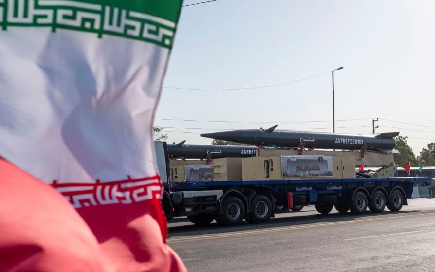 Iran's first-ever hypersonic missile, Fattah, is carried past an Iranian flag by a truck during a military parade commemorating the anniversary of the Iran-Iraq War (1980-88) outside the Khomeini Shrine in the south of Tehran, Iran, on September 21, 2024. (Photo by Morteza Nikoubazl/NurPhoto via Getty Images)