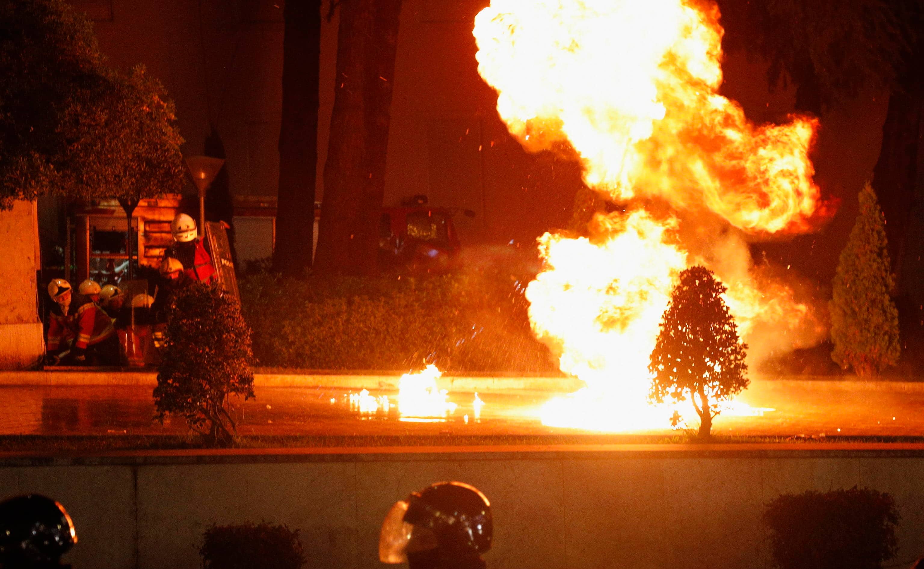 epa12609216 A Molotov cocktail explodes as firefighters (L) take refuge under their shields outside the government headquarters during an anti-government protest in Tirana, Albania, 22 December 2025. The rally follows a request by the Special Prosecution (SPAK) for the arrest of Deputy Prime Minister Balluku over alleged tender manipulation in road projects, a move that has sparked a significant political crisis for Prime Minister Rama's administration.  EPA/MALTON DIBRA