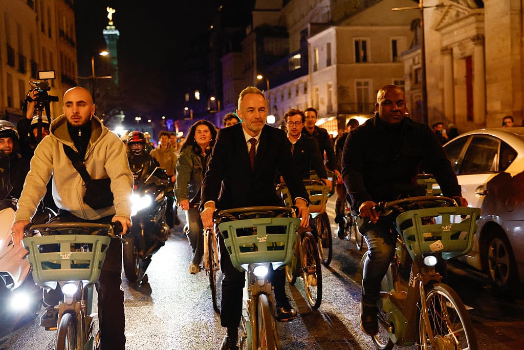 Socialistes et Apparentes' MP and Paris' Mayoral candidate Emmanuel Gregoire (C) rides a Velib' public bike-sharing bicycle heading to Paris townhall after his victory following the announcement of official results of the second round of France's 2026 municipal elections in Paris on March 22, 2026. (Photo by Kenzo TRIBOUILLARD / AFP via Getty Images)