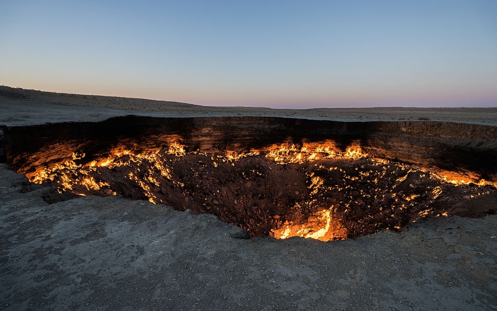 DERWEZE, TURKMENISTAN - NOVEMBER 24: The "Door to Hell" (also known as the Gate to Hell, the Crater of Fire, Darvaza Crater) is a natural gas field in Derweze, Turkmenistan, that collapsed into an underground cavern in 1971, becoming a natural gas crater. Geologists set it on fire to prevent the spread of methane gas, and it has been burning continuously since then. The diameter of the crater is 69 metres (226 ft), and its depth is 30 metres (98 ft). The crater is a popular tourist attraction. In the past five years 50,000 tourists have visited the site. The gas crater has a total area of 5,350 m2, the size of an American football field. The surrounding area is also popular for wild desert camping. (Photo by Giles Clarke/Getty Images)