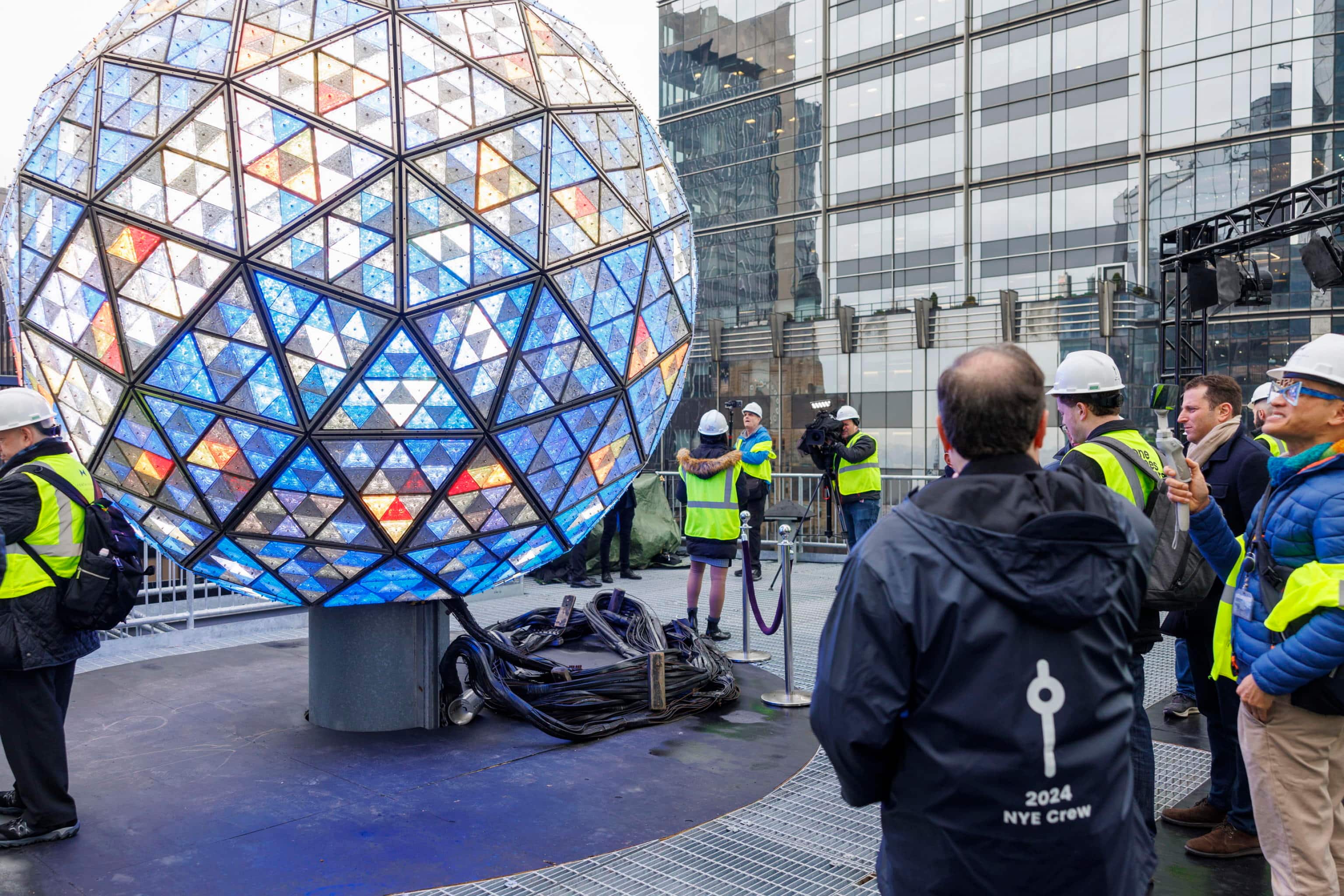 epa11046008 People view the Times Square New Year's Eve Ball atop the One Times Square building during a press visit displaying a new lighting display pattern in New York, New York, USA, 27 December 2023. This year's new design features a bowtie pattern created in partnership with Fontainebleau Las Vegas.  EPA/SARAH YENESEL