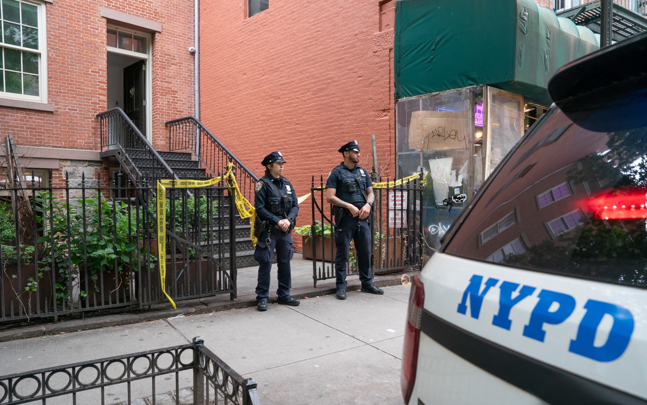 NYPD officers stand outside a home on Prince St. near Mulberry St. in Manhattan, New York on Friday, May 23, 2025, where a man was allegedly held against his will for weeks. (Barry Williams / New York Daily News via Getty Images)