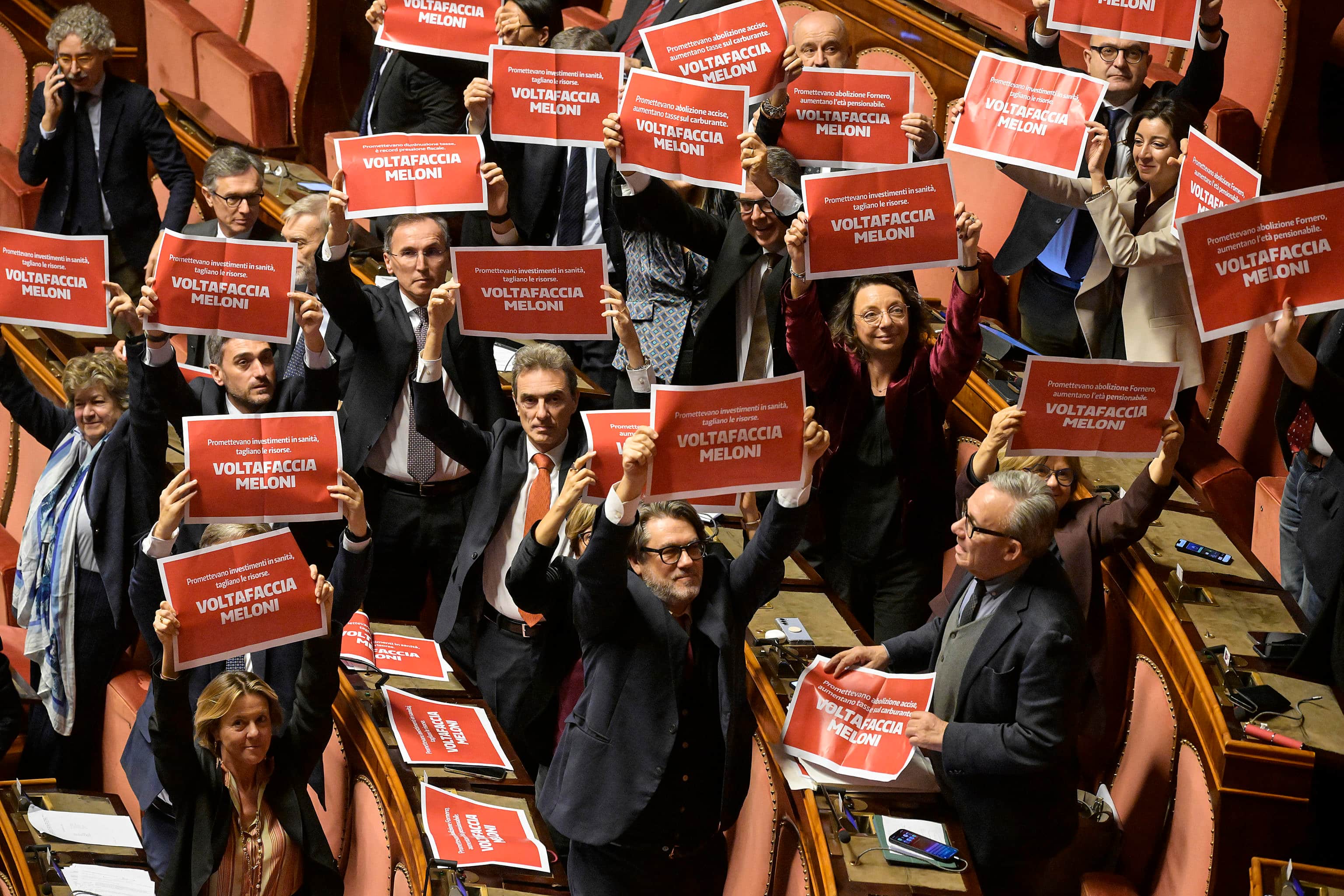 Protesta delle opposizioni in Aula al Senato poco prima del voto sulla fiducia sulla manovra, Roma, 23 dicembre 2025. I senatori di Pd, M5S e Avs hanno esposto dei cartelli rossi con la scritta bianca 'Voltafaccia Meloni'.   ANSA/RICCARDO ANTIMIANI