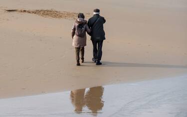 pensionati camminano sulla spiaggia