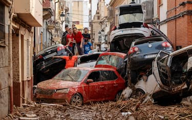 epaselect epa11695871 People climb over piled up cars in the flood-hit municipality of Paiporta, Valencia province, Spain, 01 November 2024. According to the Integrated Operational Coordination Center (CECOPI), more than 200 people have died in Valencia and neighboring provinces after floods caused by a DANA (high-altitude isolated depression) weather phenomenon hit the east of the country. According to Spain's national weather agency (AEMET), on 29 October 2024 Valencia received a year's worth of rain, causing flash floods that destroyed homes and swept away vehicles.  EPA/BIEL ALINO
