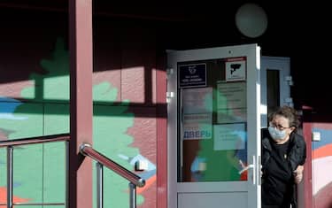 A security person wearing a face mask looks out from the door of an infectious diseases hospital in the town of Shelekhov, where an employee of the Irkutsk Antiplague Research Institute had died, in the Irkutsk region on October 7, 2026. (Photo by TATYANA MAKEYEVA / AFP)