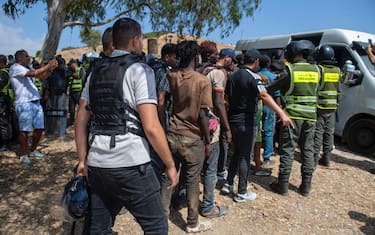 epa13171582 Moroccan security forces arrest migrants as they prevent attempts by hundreds of sub-Saharan African and Sudanese migrants gathered near Fnideq (Castillejos), Morocco, to enter the Spanish city of Ceuta, 15 August 2026. Moroccan security sources said the attempted crossings took place in a mountainous area on the outskirts of Castillejos, southwest of Ceuta.  EPA/JALAL MORCHIDI