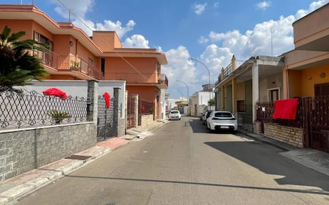Fiocchi, nastri, rose e palloncini rossi posizionati su balconi, porte e cancelli di tutte le case di via de Pietro e delle strade che conducono dall'abitazione della famiglia Isceri alla chiesa Maria Regina di Squinzano (Lecce), dove si celebreranno i funerali di Lorena Isceri, la 45enne uccisa nei giorni scorsi a Firenze dell'ex compagno. L'iniziativa è dei vicini di casa della famiglia della vittima. Su alcuni muri di abitazioni ci sono anche fiori rossi con la foto di Lorena, Squinzano 9 settembre 2026. ANSA/ISABELLA MASELLI