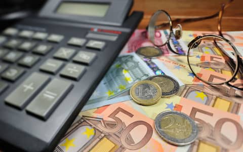 CF6KHW Conceptual image with banknotes and coins in euro currency and calculator to illustrate bank crisis in European Union countries