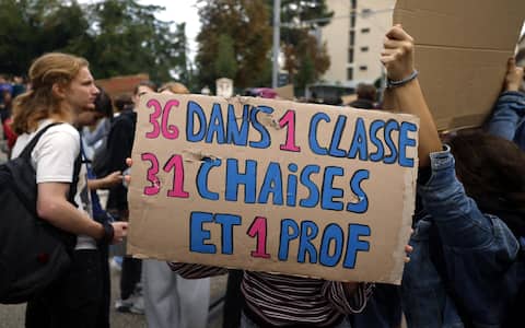 epa13284344 High school students block the entrance to their school during a protest against education conditions in Montpellier, southern France, 06 October 2026. The board reads '36 in a classroom, 31 chairs and 1 teacher.'  EPA/GUILLAUME HORCAJUELO