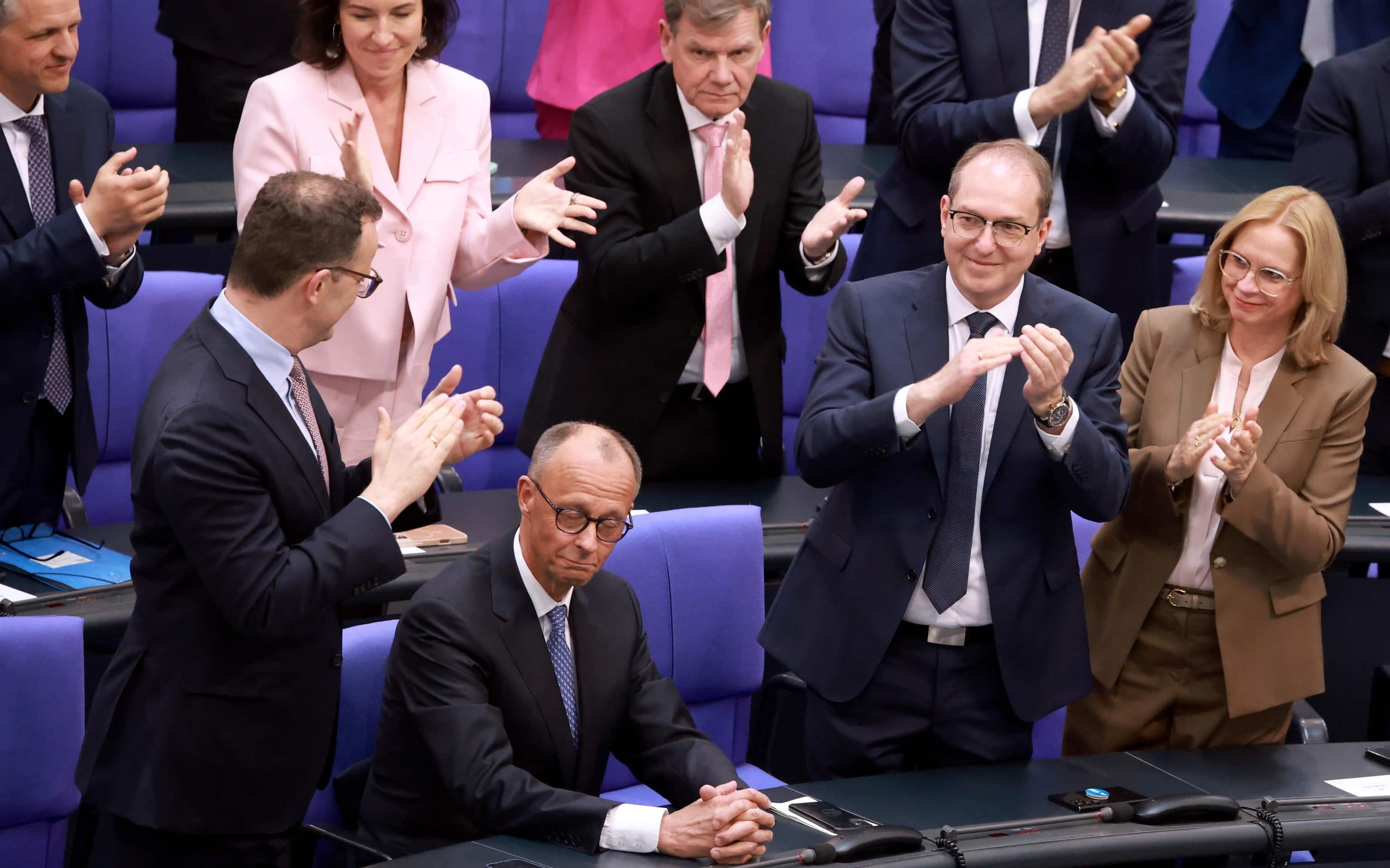 epa12077887 German Chancellor Friedrich Merz (2-L) is applauded after his election at the Bundestag in Berlin, Germany, 06 May 2025. The new German government is expected to be formed between the Union parties of Christian Democratic Union (CDU) and Christian Social Union (CSU) and the coalition partner Social Democratic Party (SPD).  EPA/CLEMENS BILAN